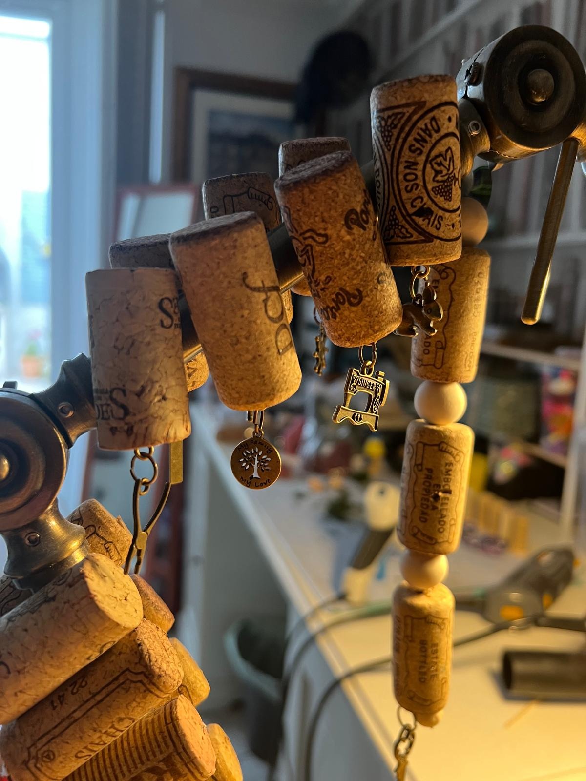 Wine cork decorations with dangling metal charms displayed on a stand