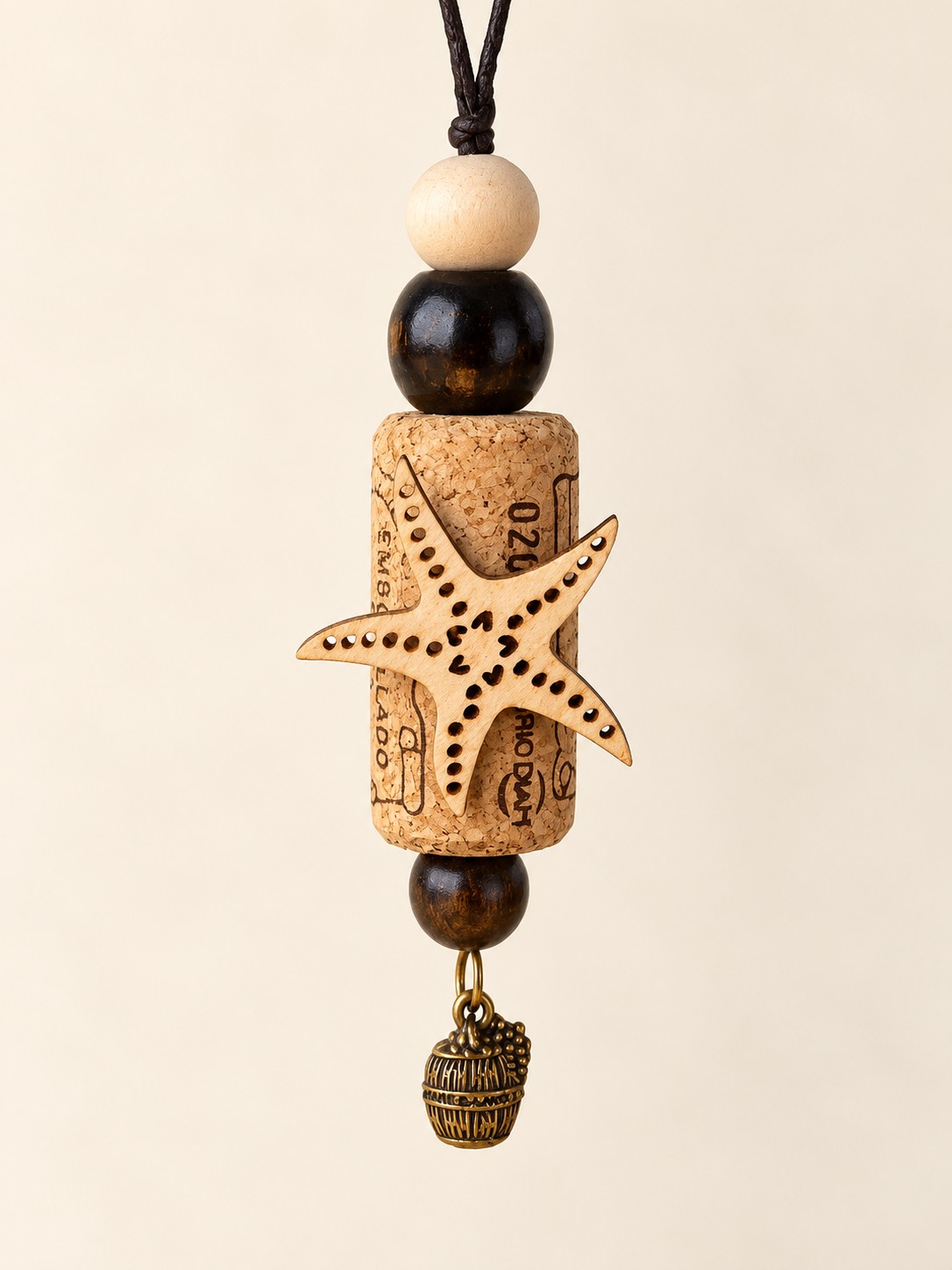 a starfish cork hanging decoration with black and cream beads and a barrel charm