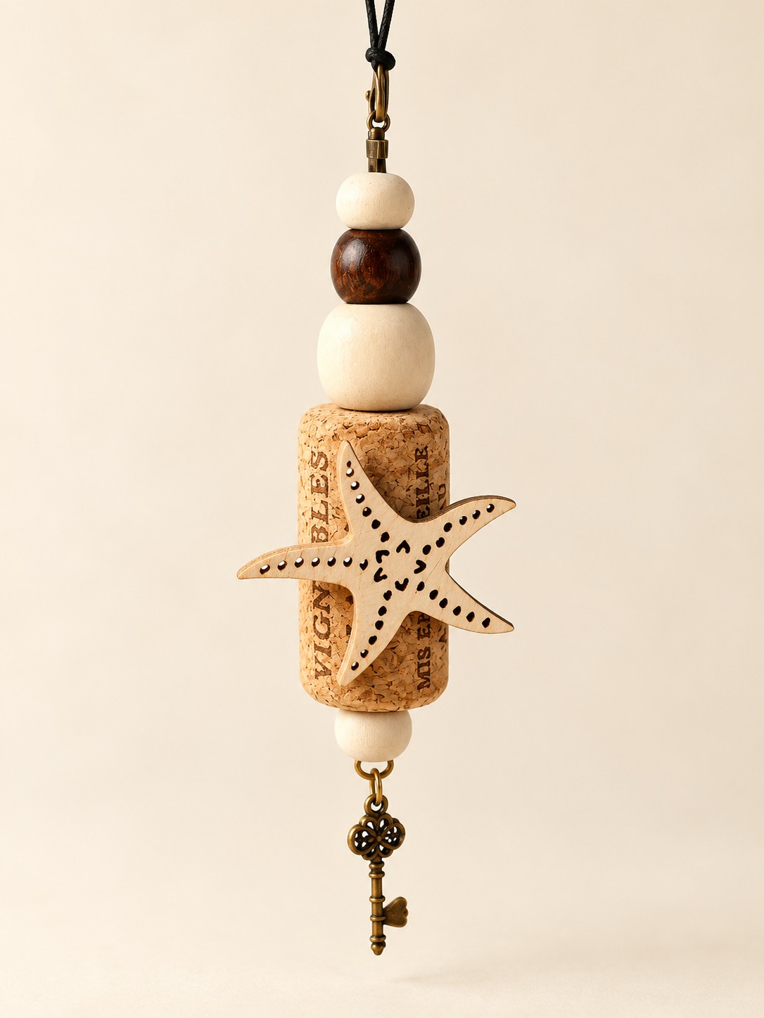 a starfish cork hanging decoration with black and cream beads and a key charm